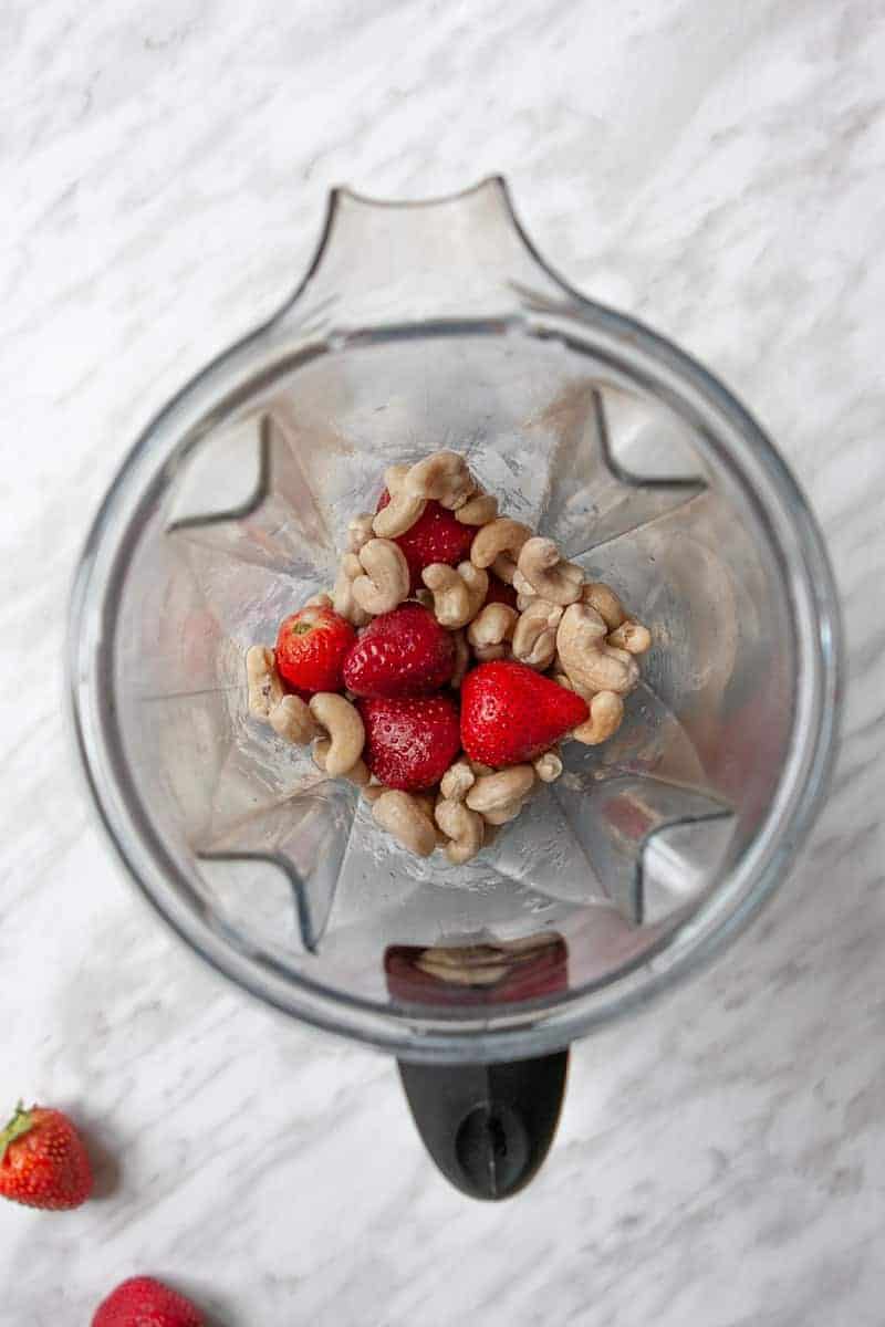Strawberries and cashews in blender container
