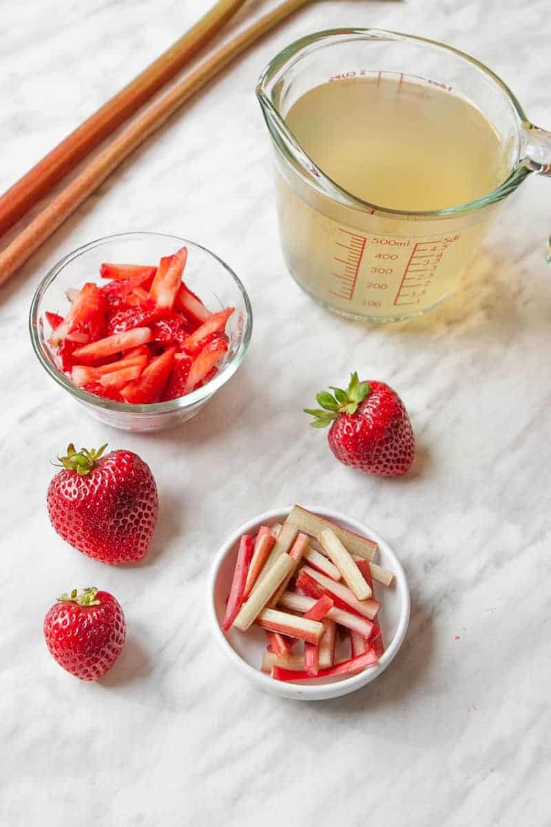 kombucha in cup, cut strawberries and rhurbarb